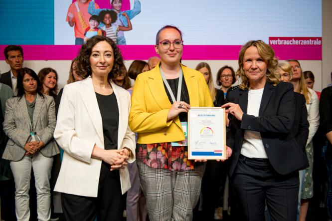 Auszeichnung durch die Vorsitzende der Verbraucherzentrale und Bundesministerin für Ver-braucherschutz Steffi Lemke, entgegengenommen durch Fr. Ledig, Lehrkraft für Ethik und Geschichte